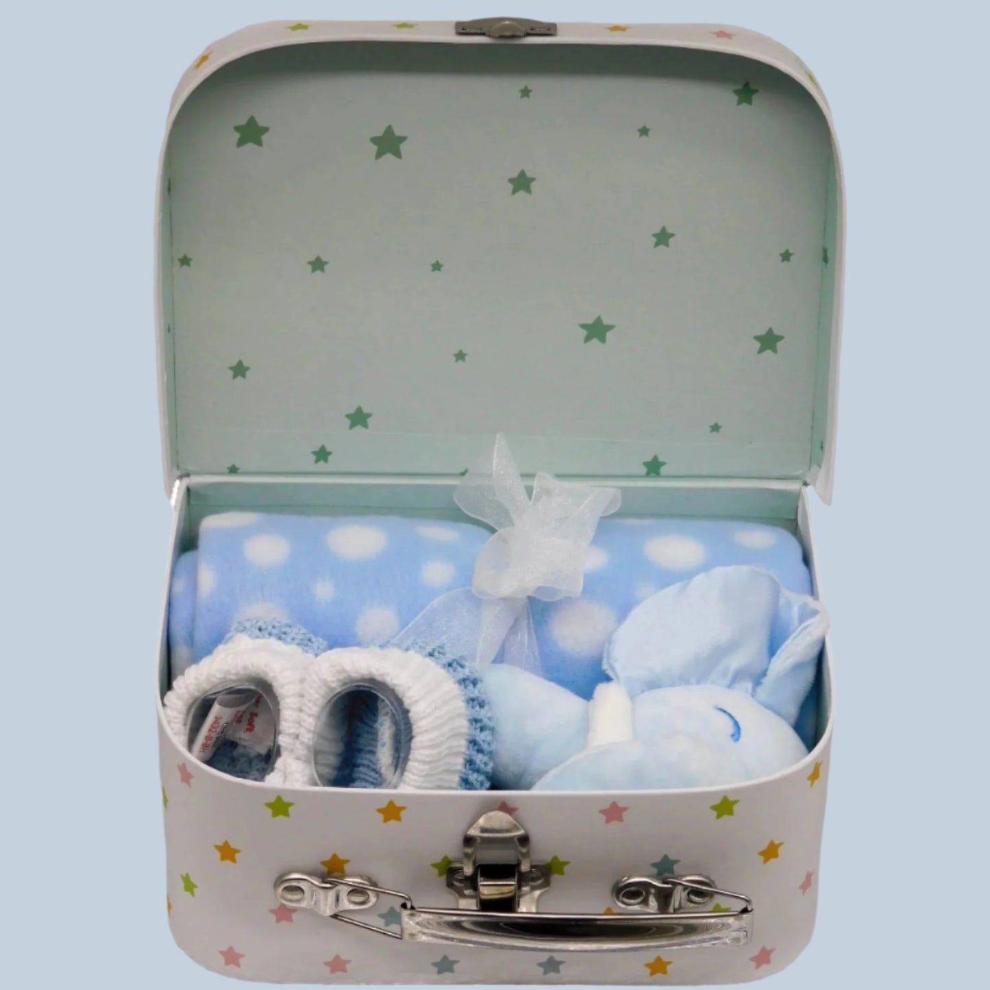 Keepsake box suitcase with baby blanket, plush elephant rattle and booties on a blue background