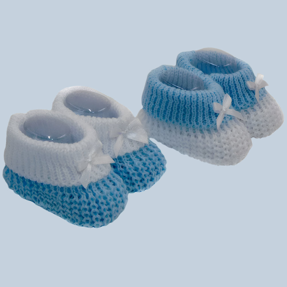 Blue and white knitted baby booties on a pale blue background
