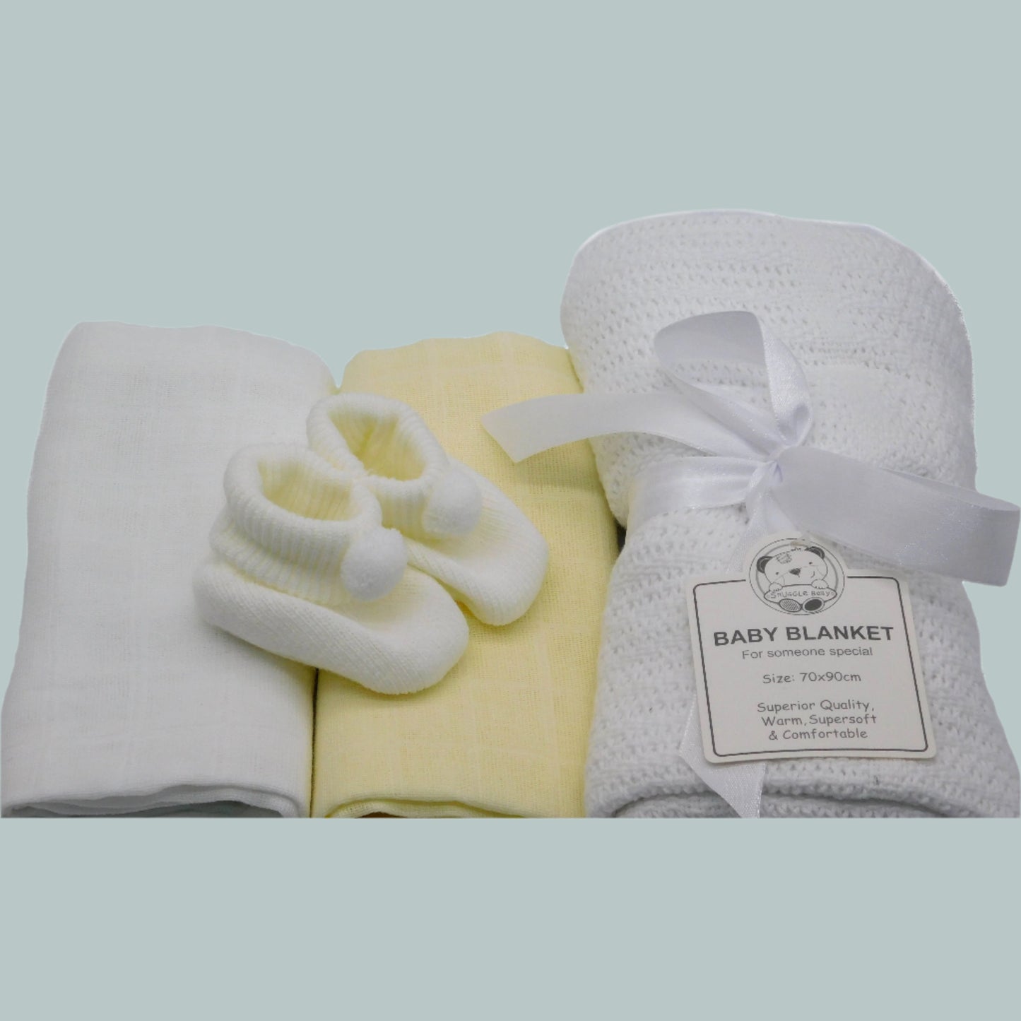 Baby blanket, booties, and 2 muslin squares on a neutral background