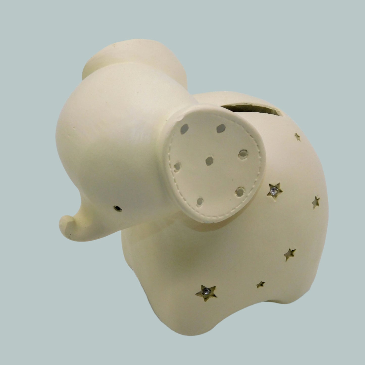 Beige elephant money box with star patterns on a neutral background