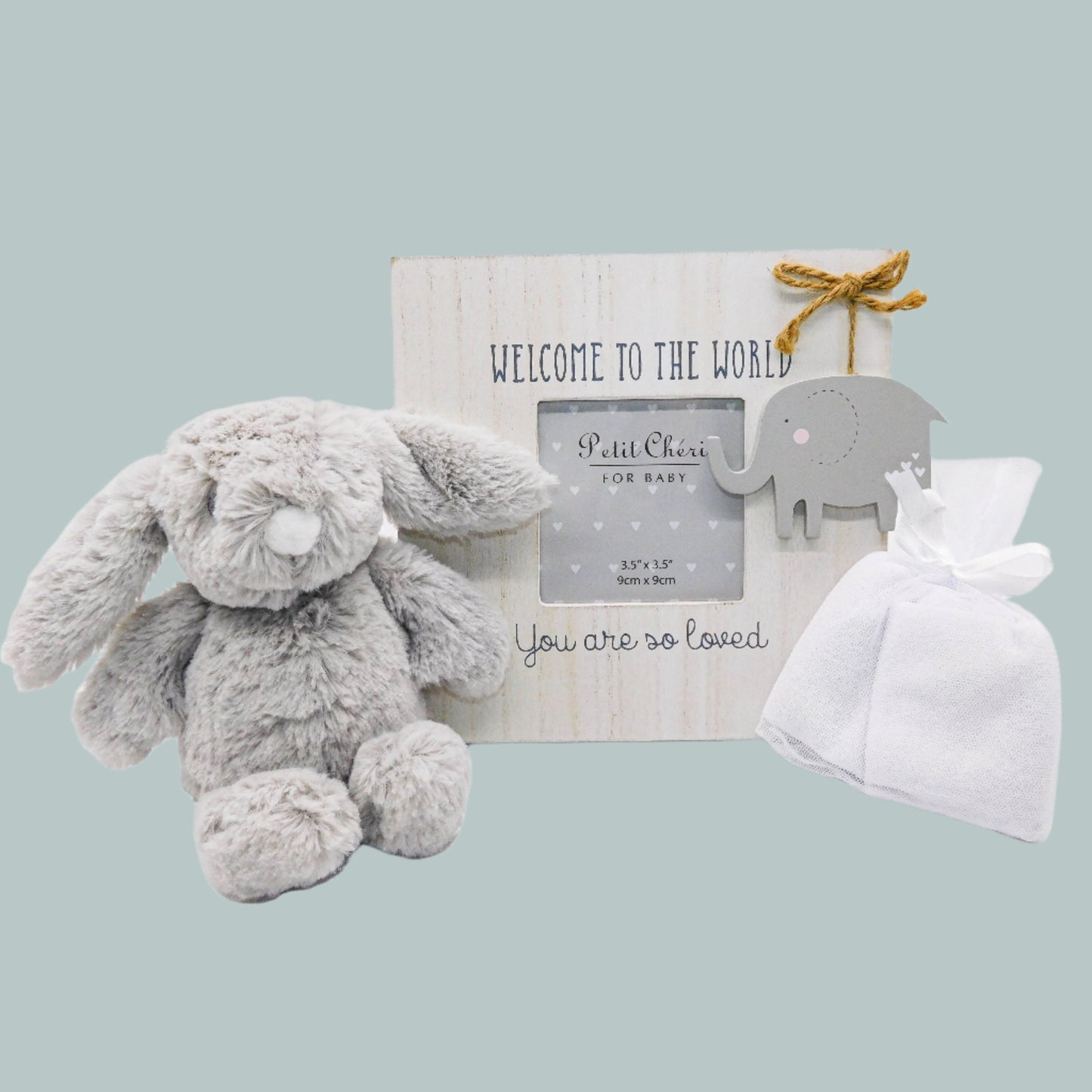 Baby gift set with plush bunny, photo frame and wash cloths on a neutral background