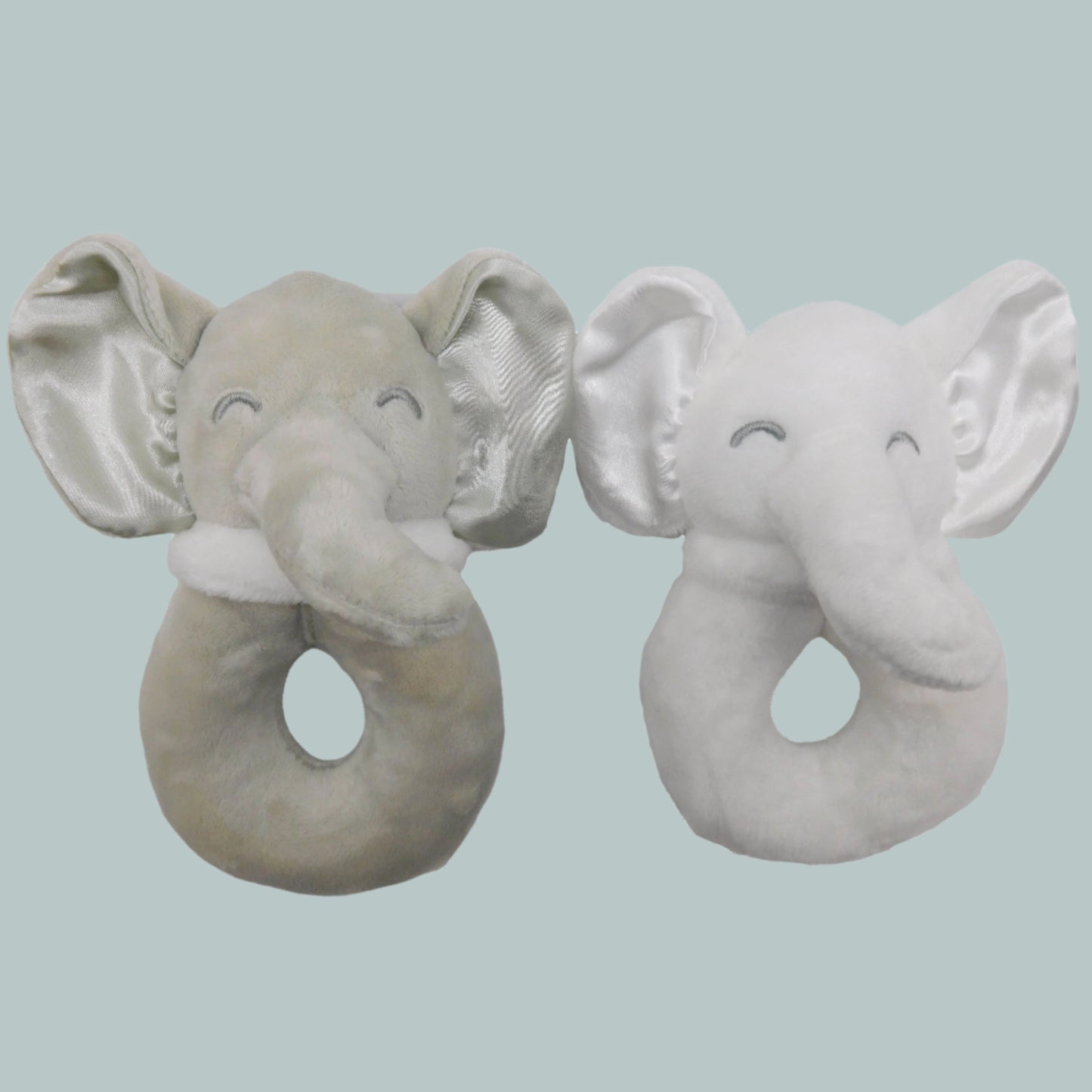 Two plush elephant baby rattles toys on a neutral background