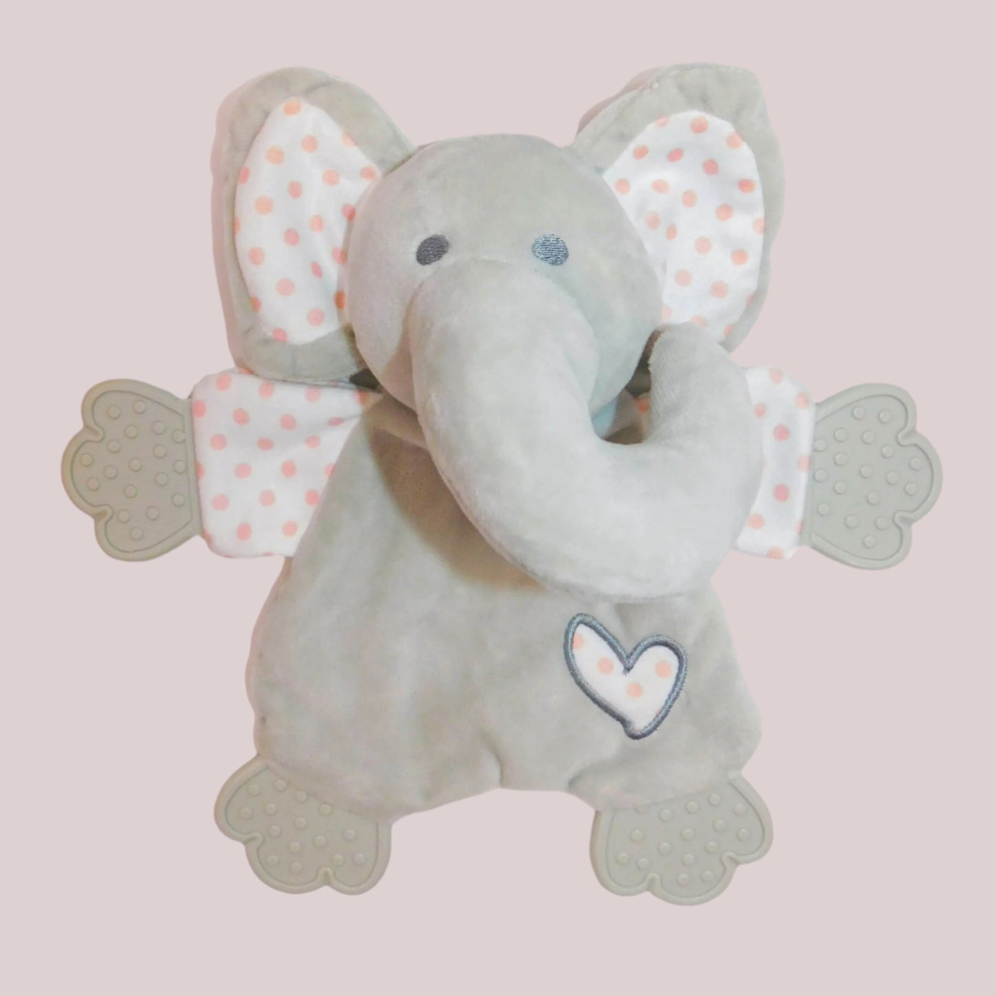Plush grey elephant comforter and teether with polka dot ears and a heart on a pale pink background