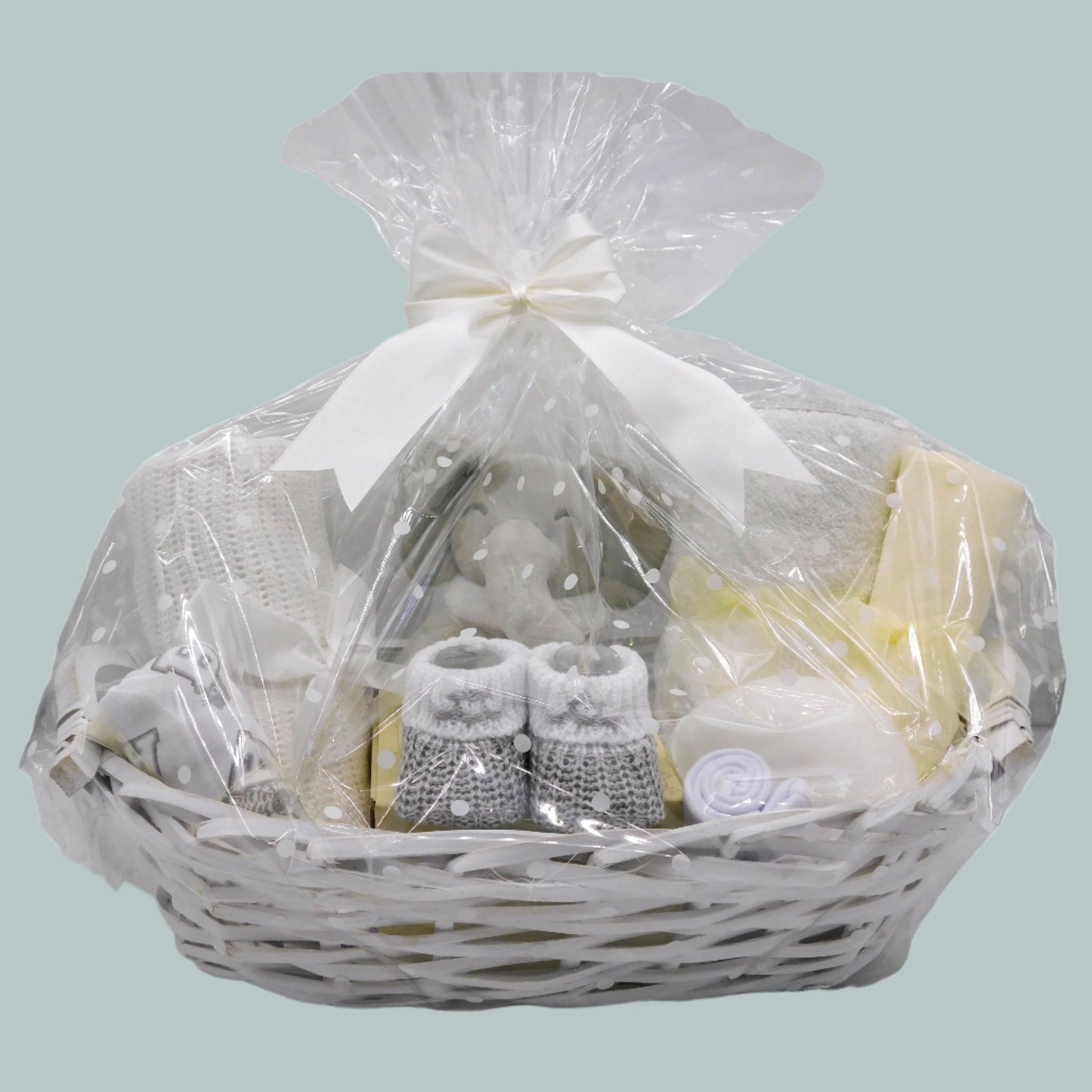Baby gift basket with white cellophane wrap on a neutral background