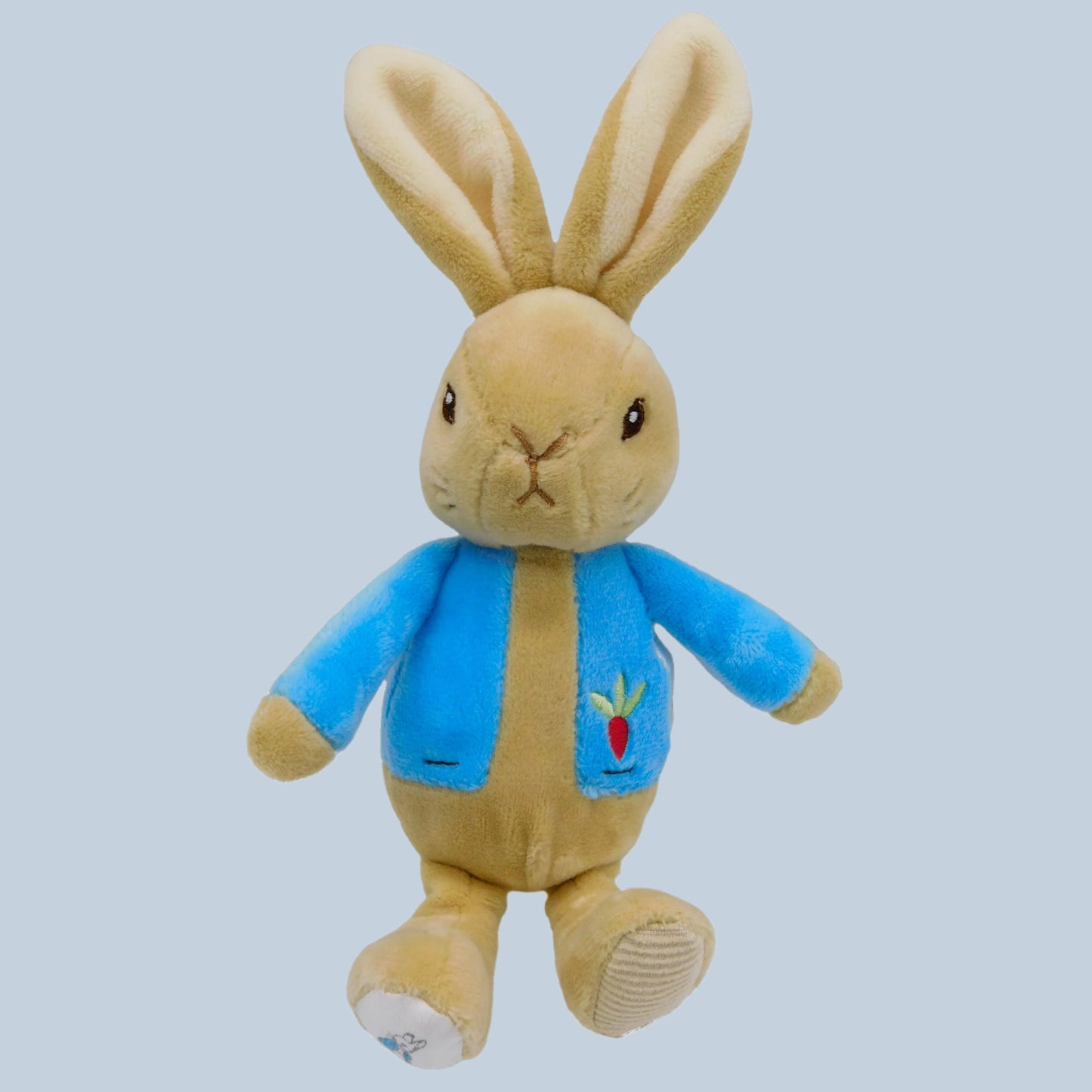 Peter Rabbit Plush bean rattle with a blue jacket on a pale blue background