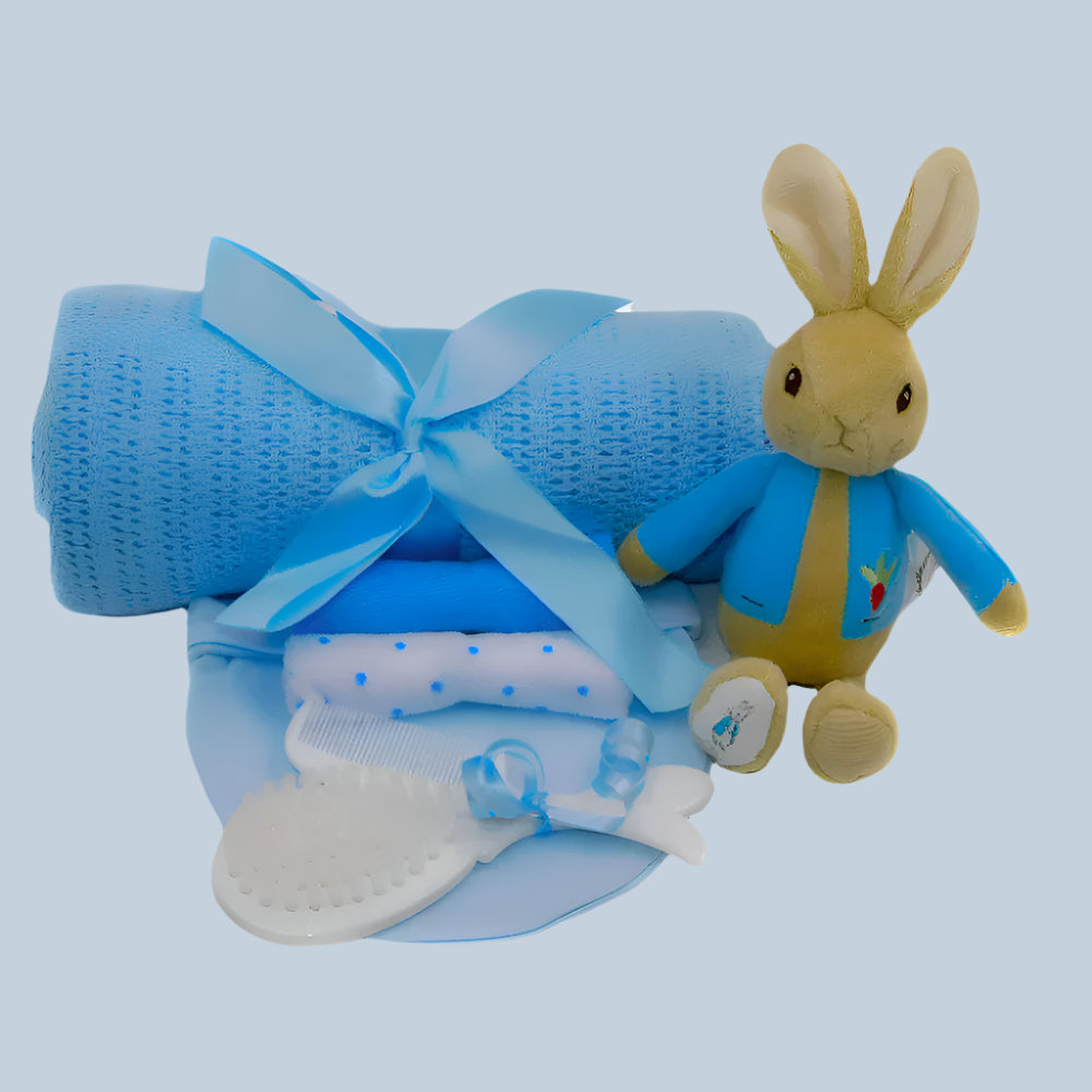 Peter Rabbit Baby Boy gift set with blue blanket, plush Peter Rabbit bean rattle, and baby items on a white background