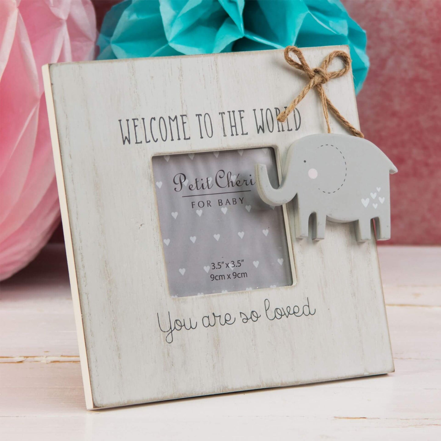 Wooden photo frame with elephant decoration and text 'Welcome to the world. You are so loved.' on a light wooden surface.