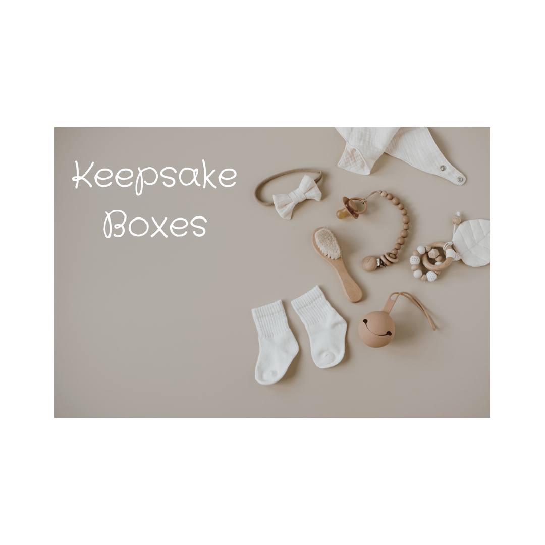 A collection of small baby items including socks, hairbrush and wooden teether, and the text 'Keepsake Boxes'
