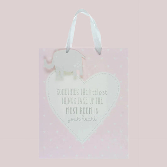 Large pink baby gift bag with white polka dots and the wording 'Sometimes the littlest things take up the most room in your heart' with an elephant gift tag.