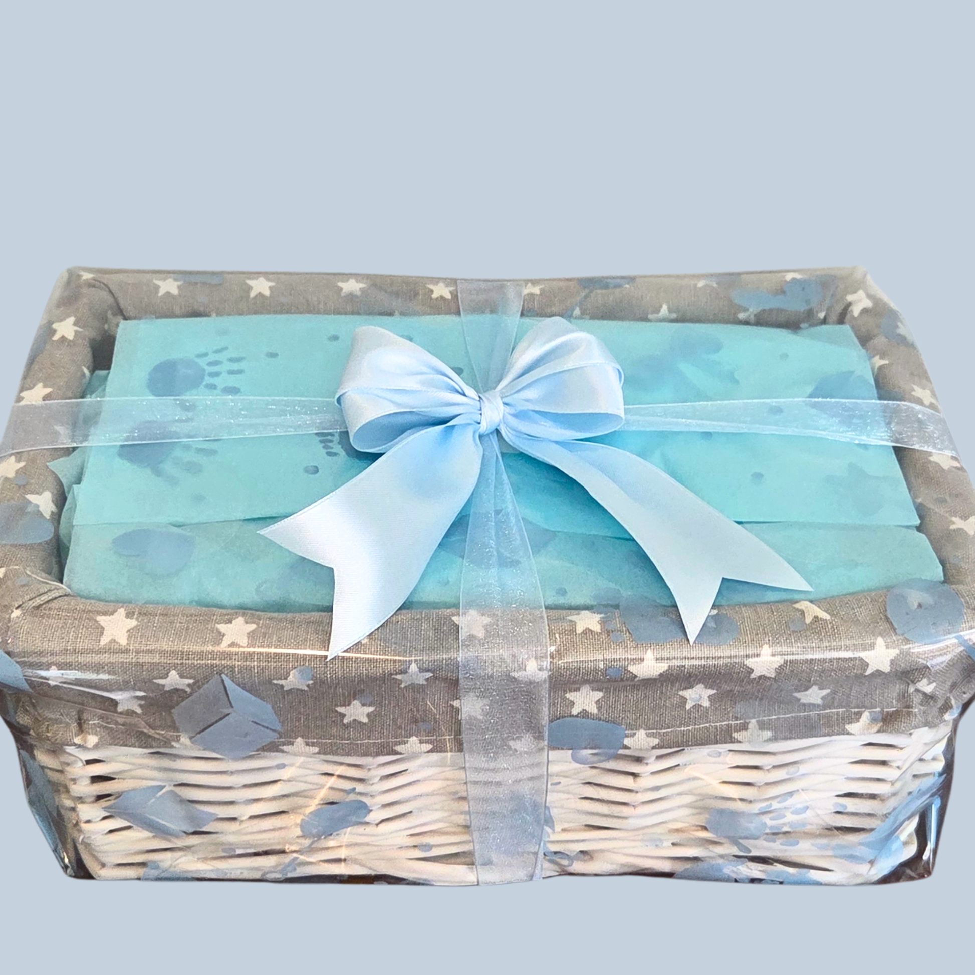 Baby Gift basket with blue ribbon and baby-themed items on a light gray background