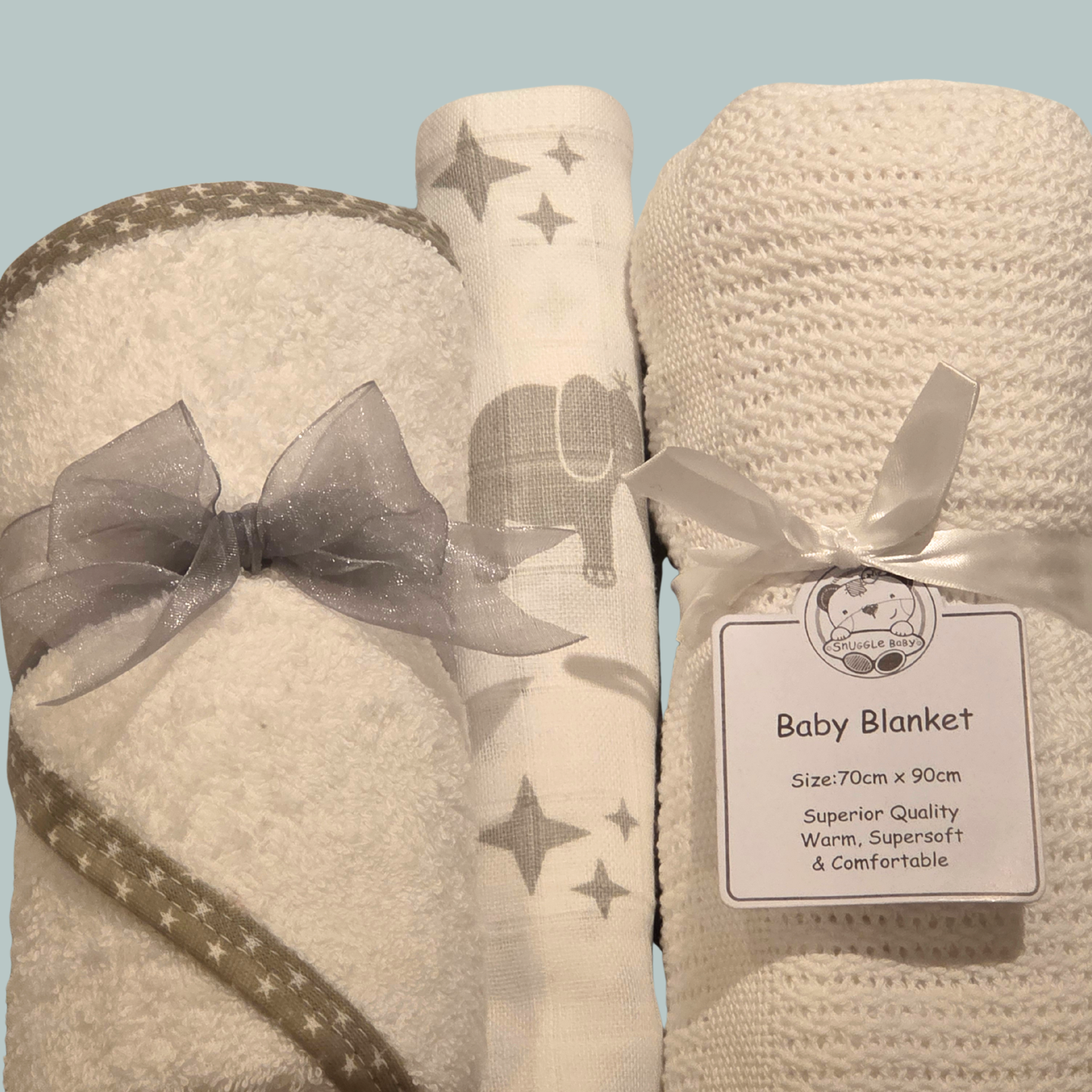 Baby hooded towel, elephant design muslin and cotton cellular blanket on a light teal background