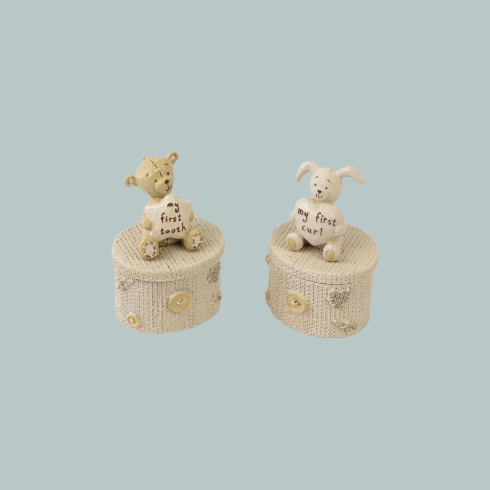 Button Corner My First Tooth and Curl boxes with teddy bear and dog figurines on a neutral background