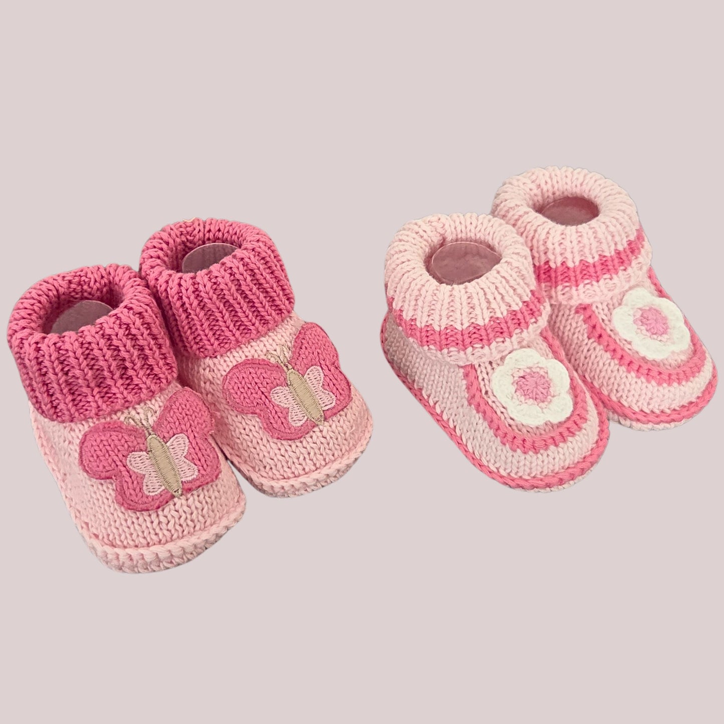 Two pairs of cotton bootees, one with a butterfly motif and one with a white & pink flower motif