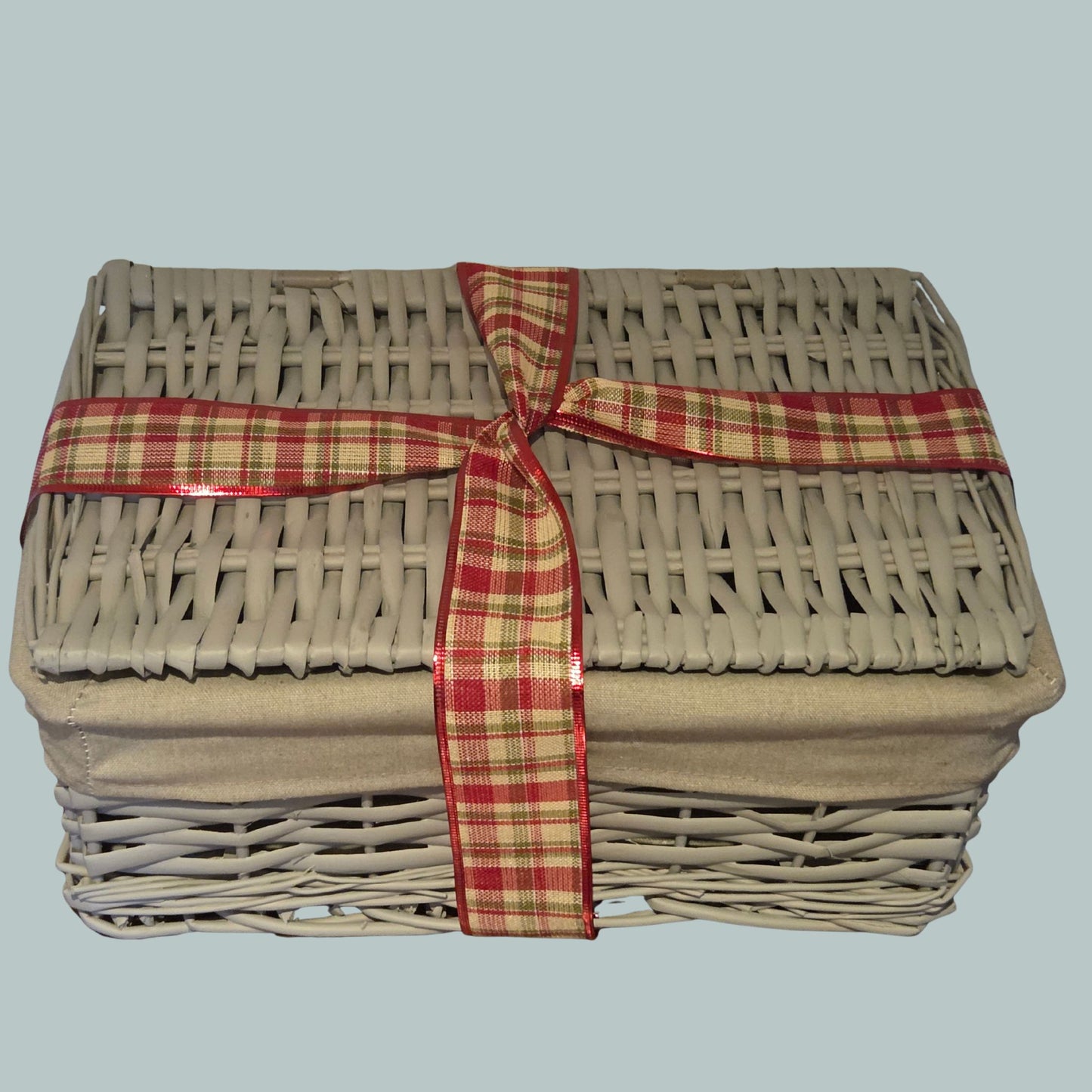 Grey wicker hamper basket wrapped with a tartan  ribbon 