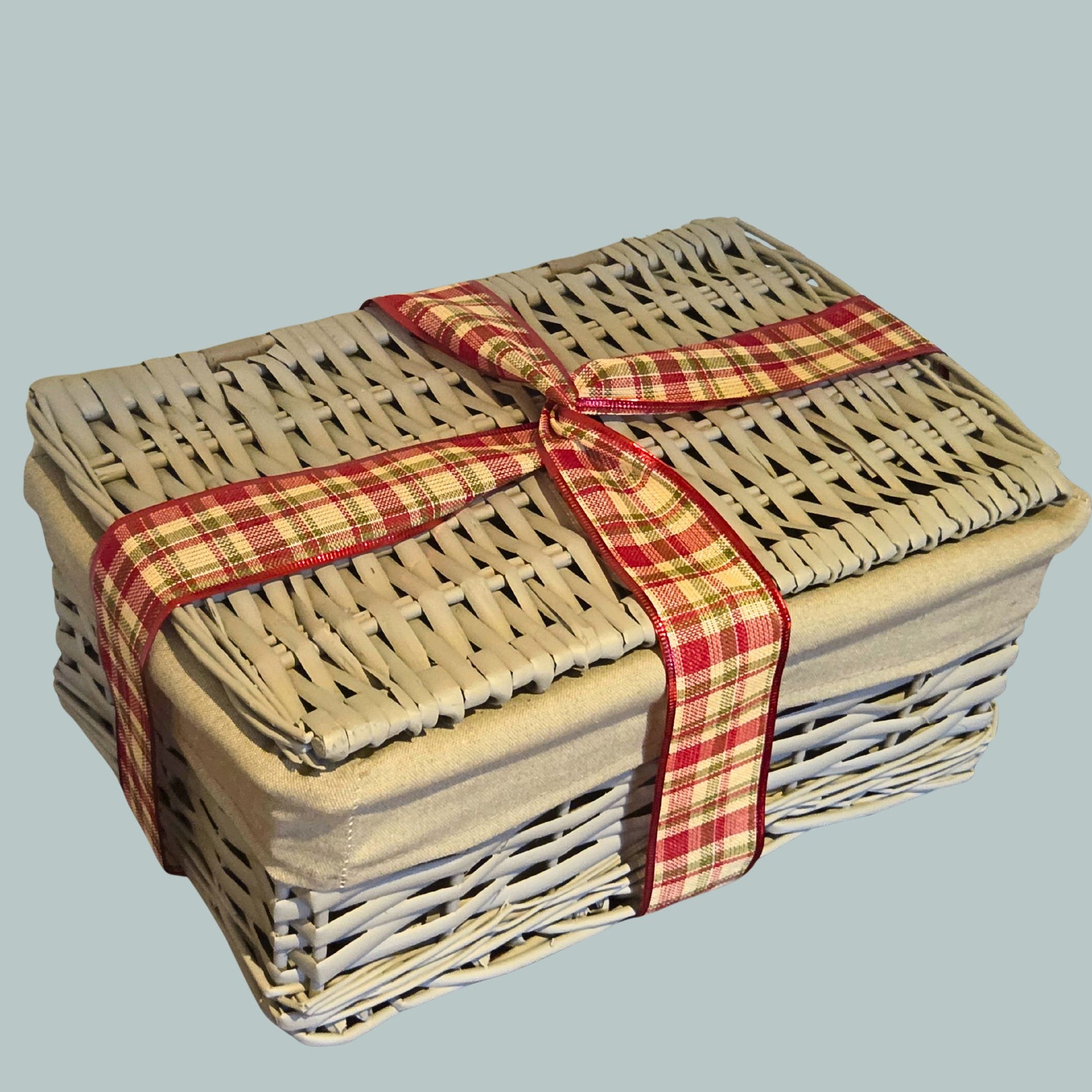 Wicker hamper basket wrapped with a tartan ribbon 