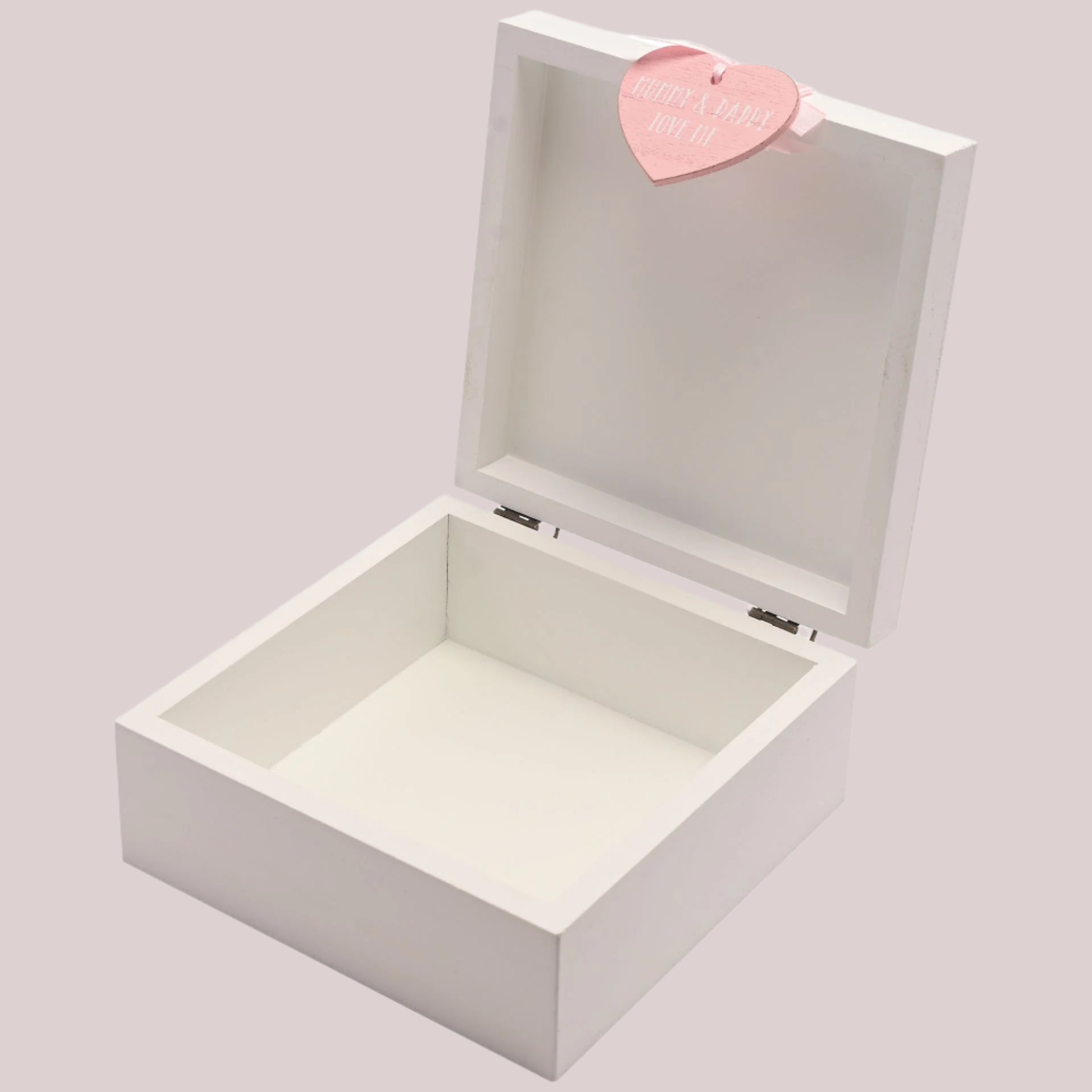 White wooden keepsake box with a pink heart-shaped tag on a pale pink background